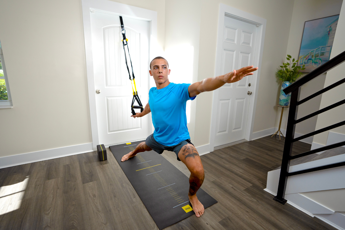 Person performing small space workout with TRX suspension trainer in compact home gym