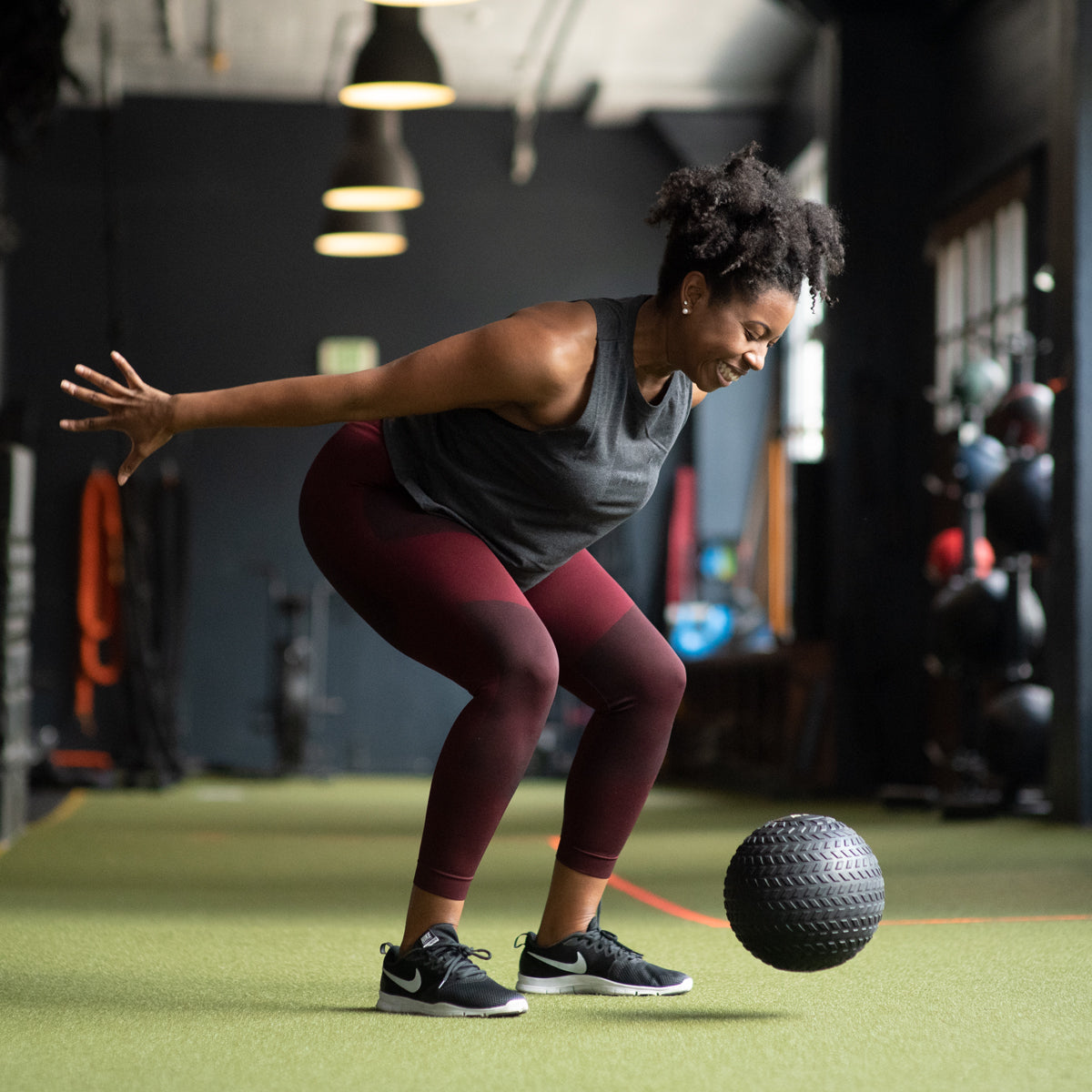 trainer throwing trx slam ball on floor