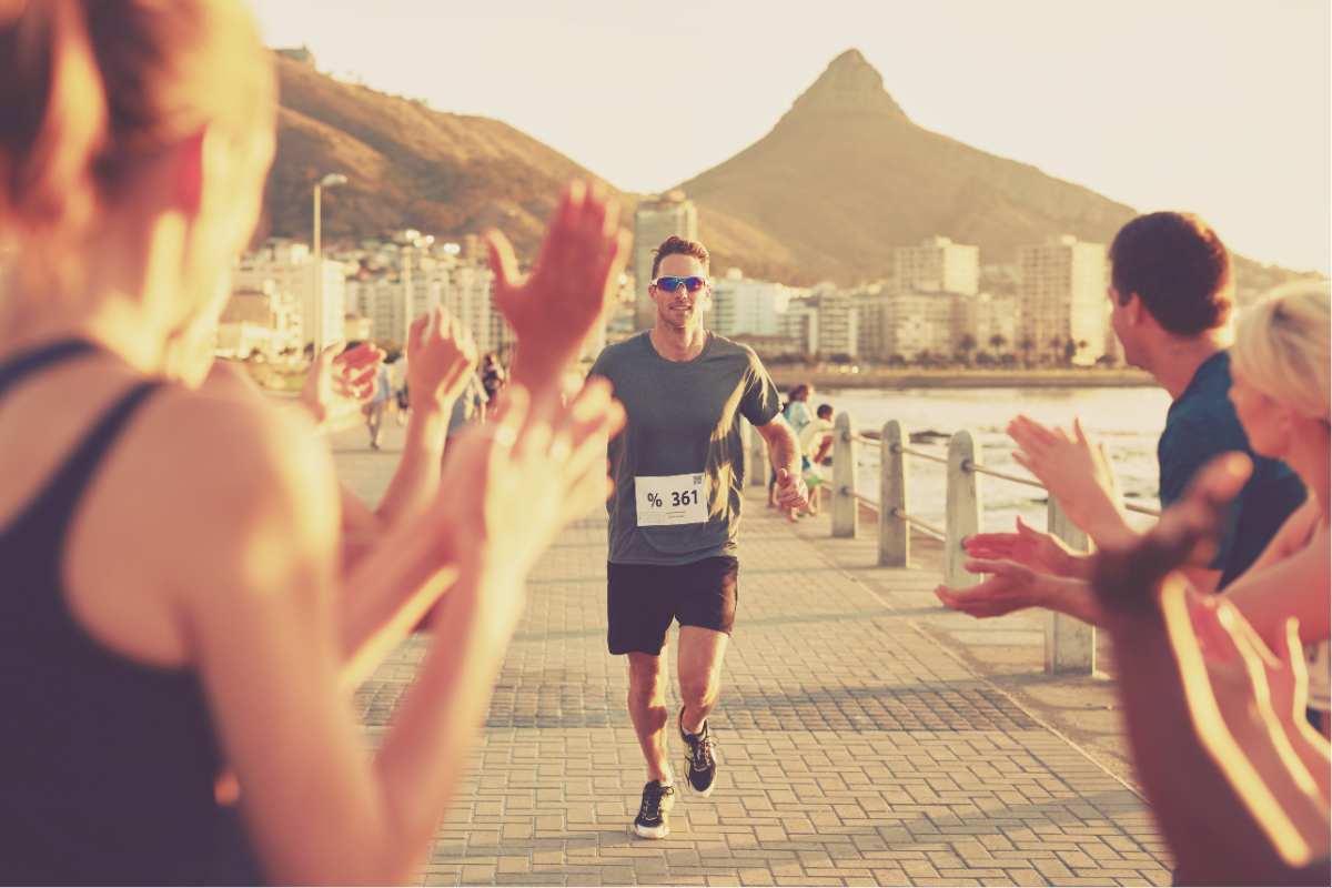 Beginner runner following half marathon training plan on outdoor track with TRX equipment nearby 