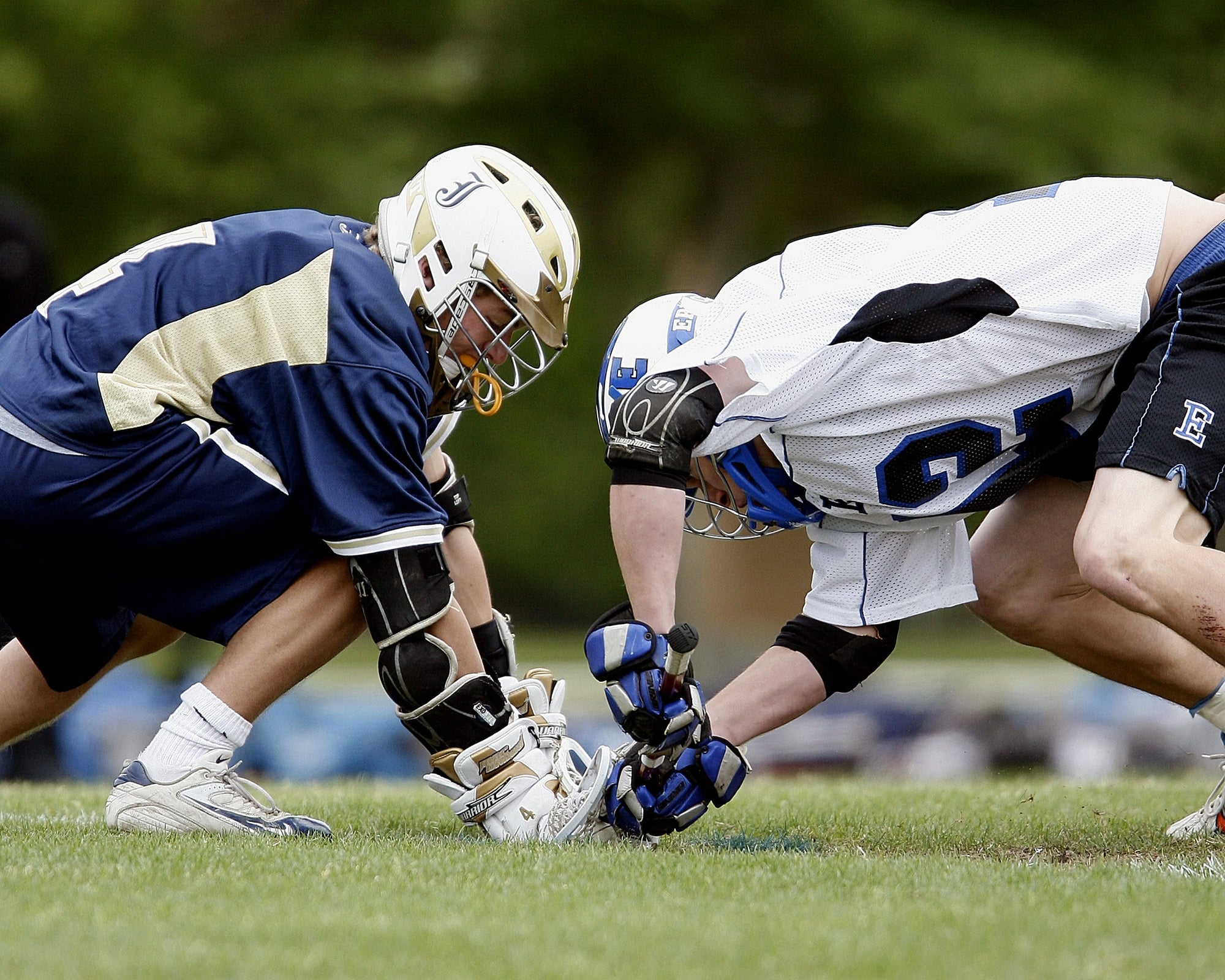 lacrosse players facing off