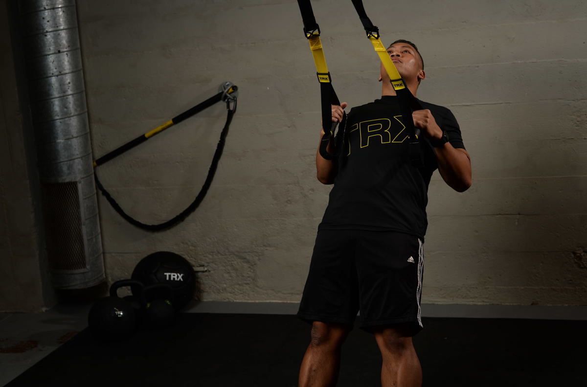 trainer doing trx rows