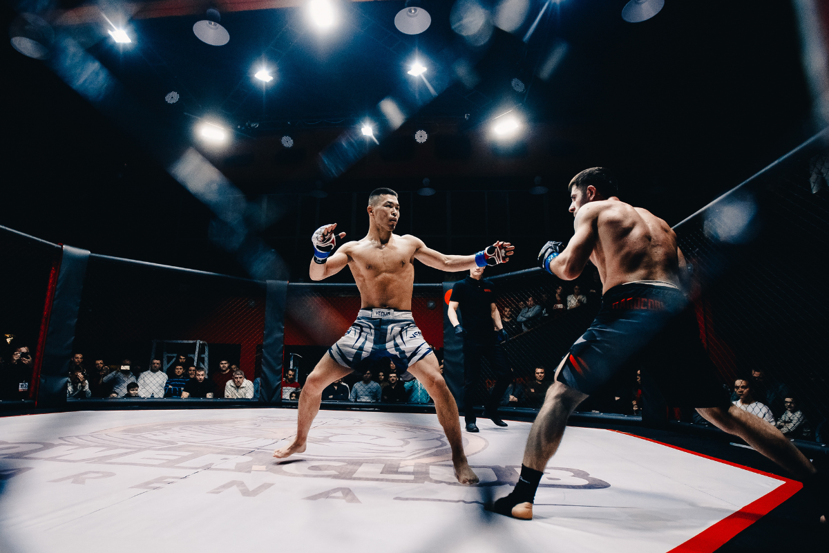 MMA fighter performing TRX suspension training for fight conditioning in a gym