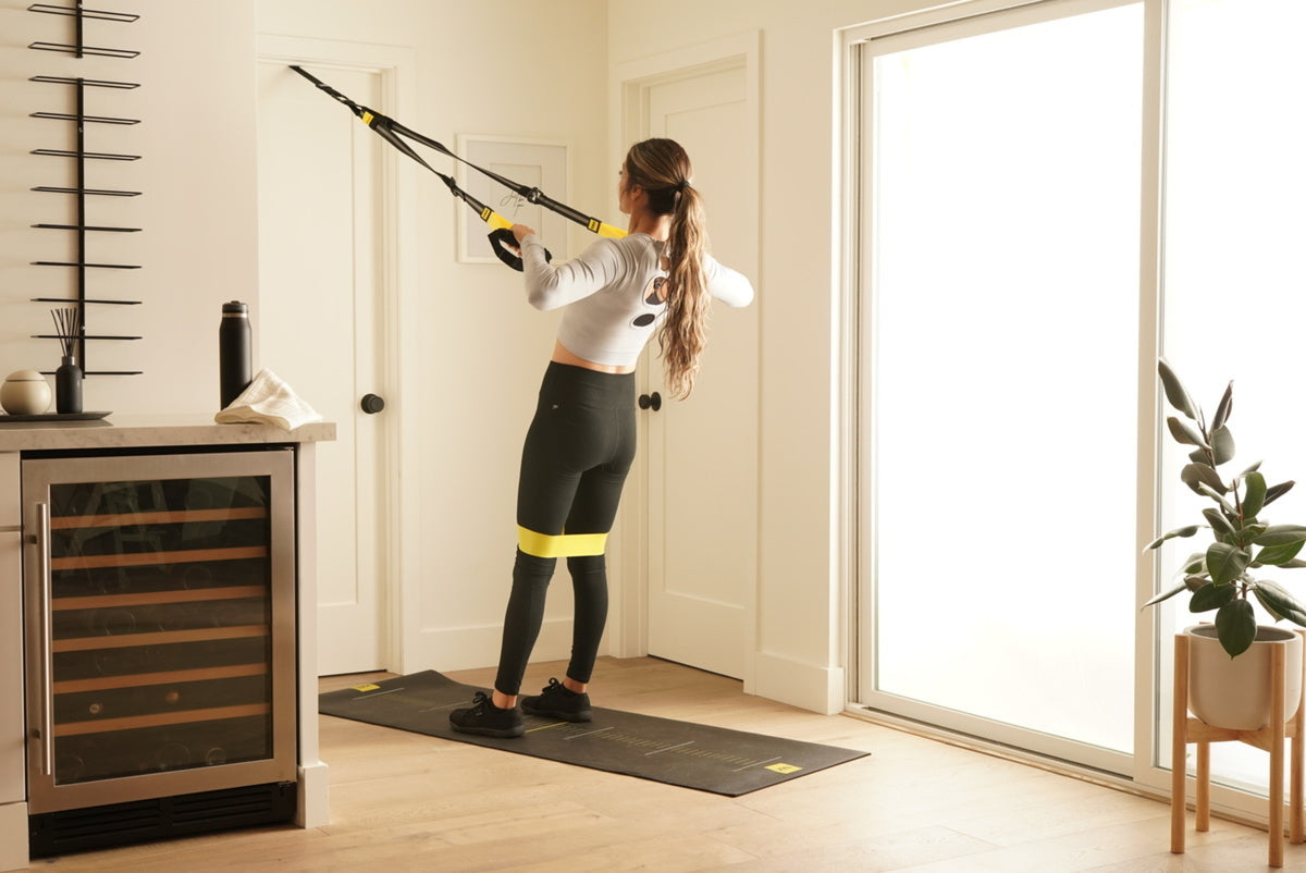 female trainer working out from trx home gym